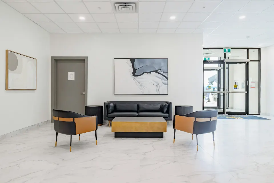 Heller Wartebereich mit Ledersofa und Sesseln